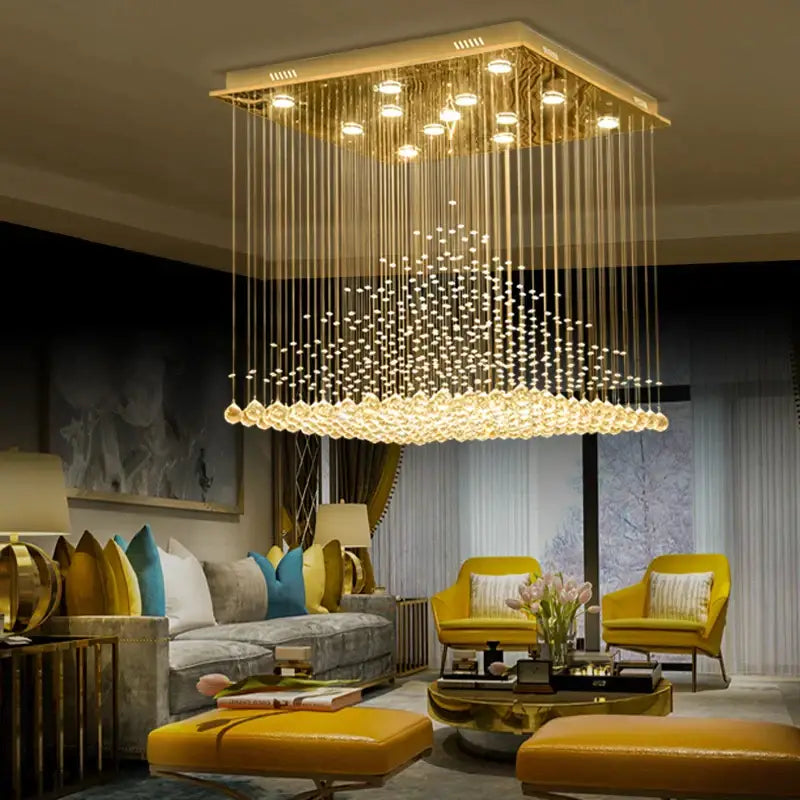 Golden square chandelier with cascading clear and amber crystal beads and illuminated pendant lights for elegant duplex villa hotel decorbites elegant duplex