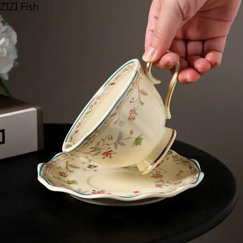 Cream-colored elegant floral ceramic cup and saucer set with gold trim and soft pink green floral patterns porcelain