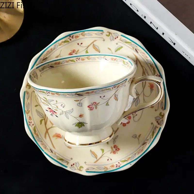 Cream-colored elegant floral ceramic cup and saucer set with delicate pink green and gold patterns for dining room use