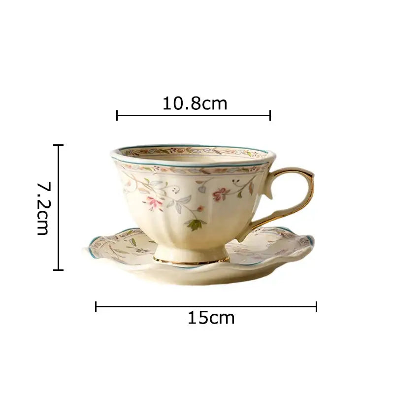 Cream-colored elegant floral ceramic cup and saucer set with pink and green patterns and gold-trimmed porcelain rim and handle