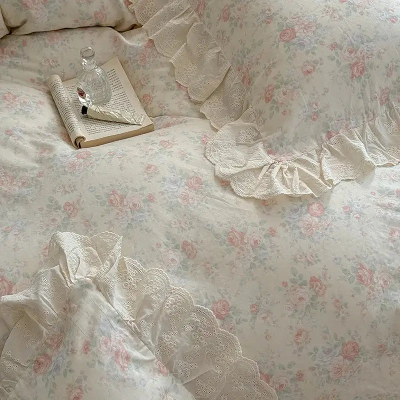 Cream-colored bedding set with elegant floral lace ruffles and embroidered rose patterns for a refined bedroom decor