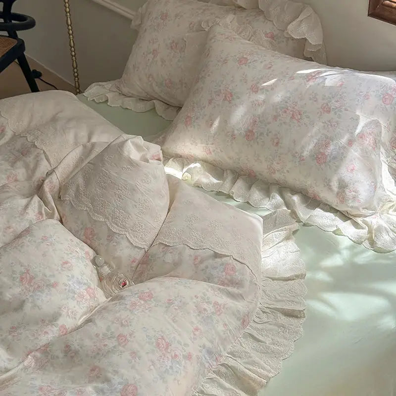 Elegant floral lace ruffles bedding set featuring a delicate ivory floral duvet with lace trim and soft ruffled edges