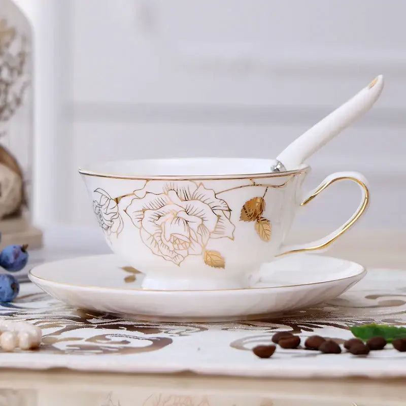 Elegant floral porcelain tea cup set with gold trim and integrated white ceramic spoon in a matching cup set