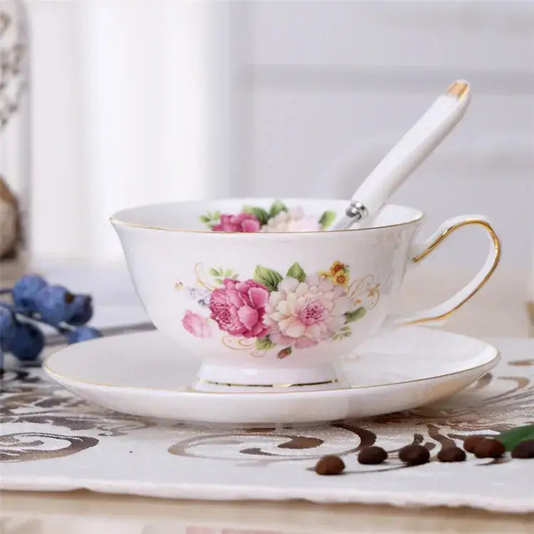 Elegant floral porcelain tea cup set featuring a delicate white cup with pink and peach flowers and gold trim accents