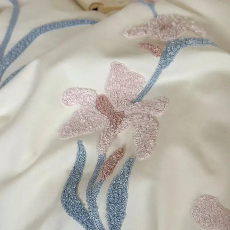 Cream satin bedding set with elegant flower embroidery featuring soft pink and dusty blue textured petals decorbites elegant flower