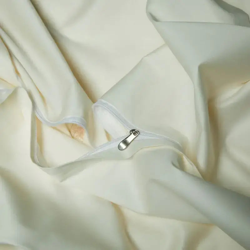 Cream satin bedding set with elegant flowers embroidery and smooth texture featuring a silver zipper pull