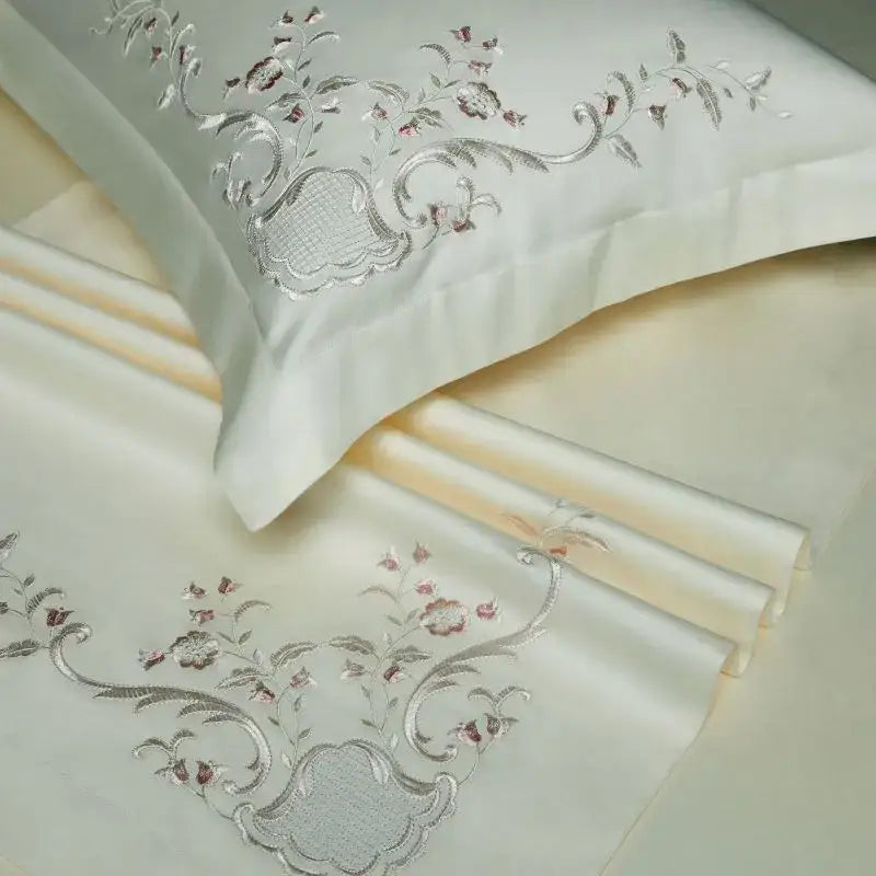 Cream-colored satin pillowcase with intricate silver and rose-gold floral embroidery from decorbites elegant flowers bedding set
