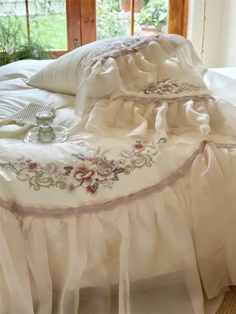 Cream-colored cotton bed skirt with ruffled lace trim and elegant flowers embroidery in decorbites bedding set