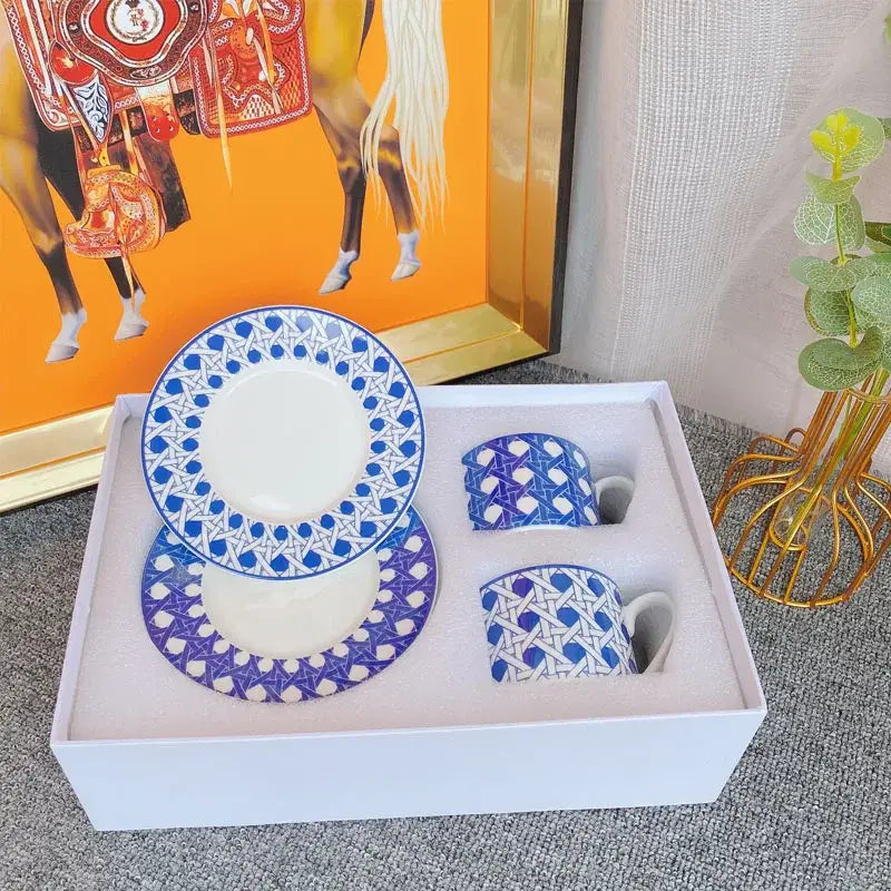 Elegant geometric bone china tea cup set in white with blue and purple patterns featuring two mugs and saucers