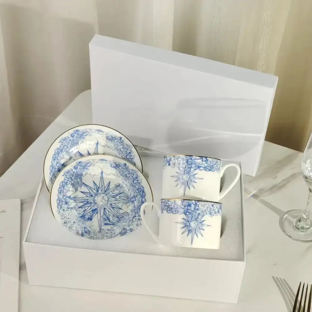 Elegant white bone china tea cup set with blue starburst floral patterns and gold rims for dining room use