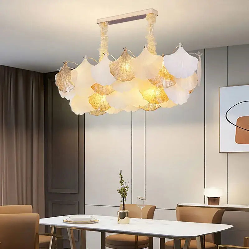 A modern decorbites ginkgo gold led chandelier with translucent white and gold leaf-shaped shades for living room light