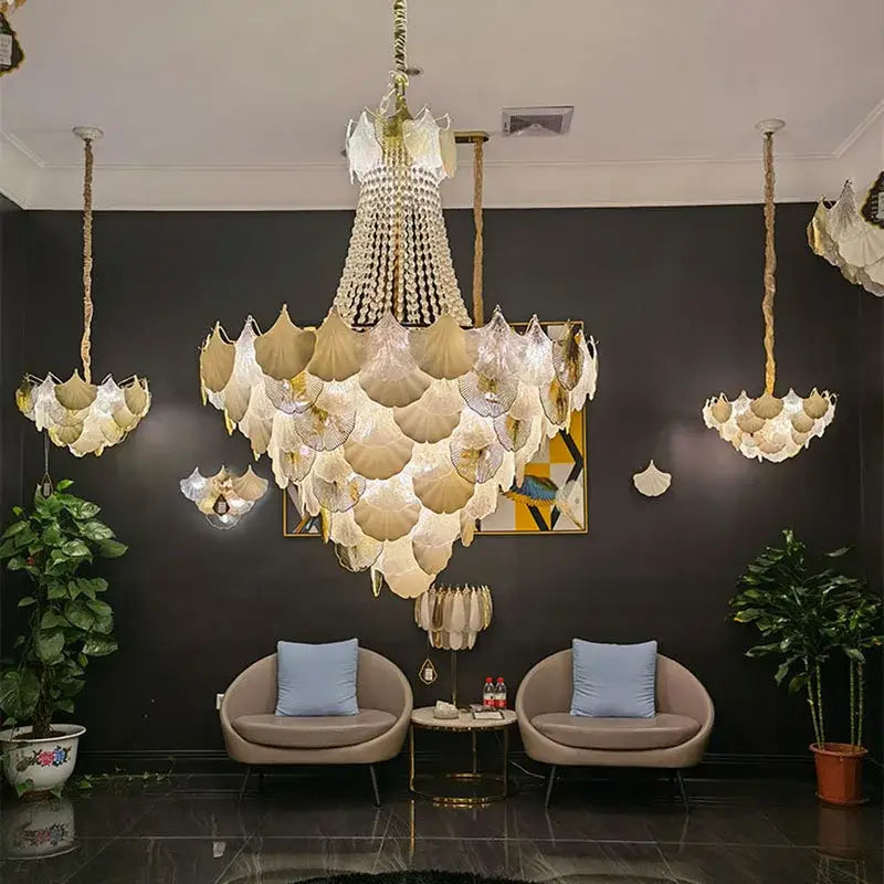A large multi-tiered decorbites ginkgo gold led chandelier with layered translucent white and gold glass shades for living room decor
