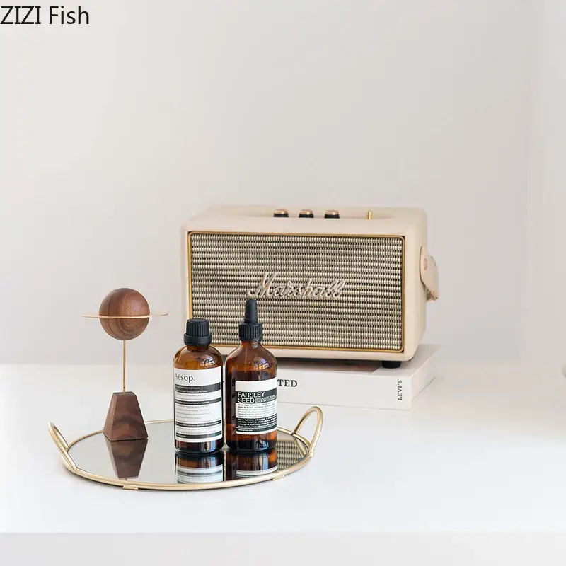 Cream-colored marshall speaker with textured grille and gold-tone accents on decorbites brass handle storage tray