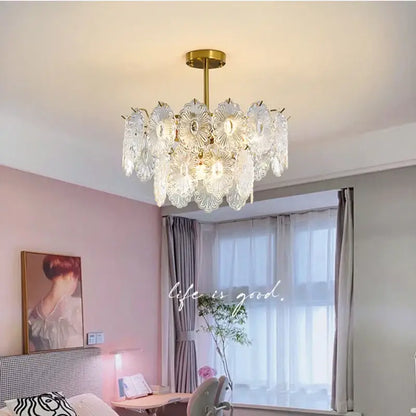 A decorbites elegant glass chandelier with gold-toned metal frame and petal-shaped shades for dining room lighting