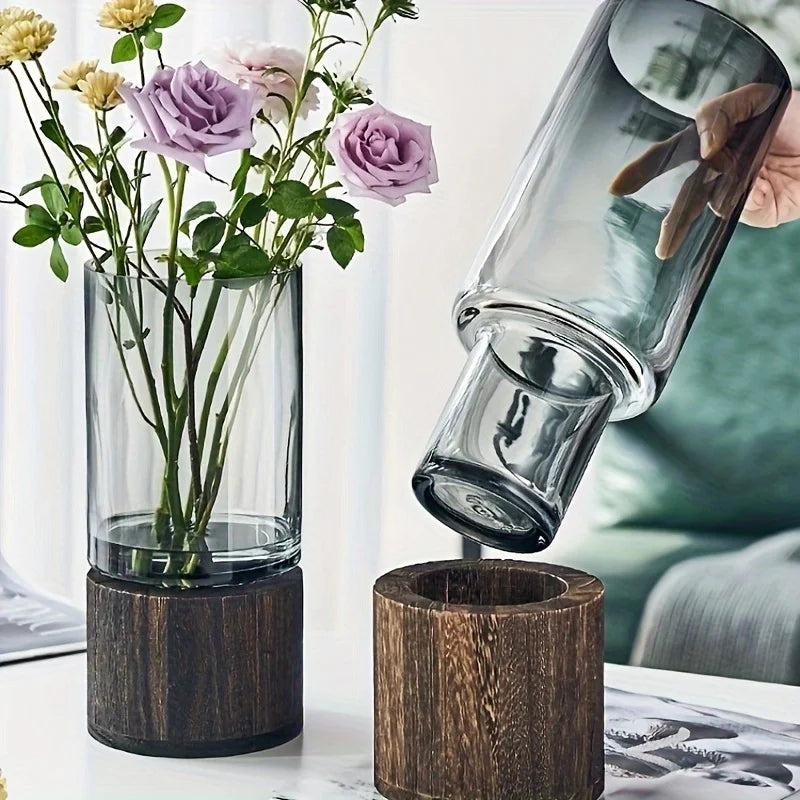Elegant glass vase with dark wood base holding purple and yellow flowers for modern hydroponic tabletop decor