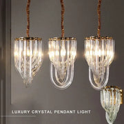 Three elegant glass crystal pendant lights with gold metal accents and twisted copper chains for kitchen island lighting