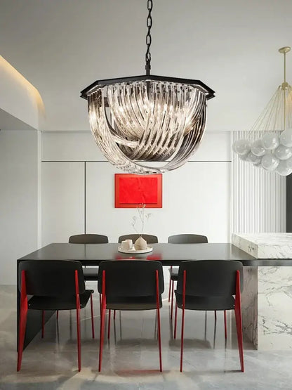 A modern black metal pendant light with geometric frame and cascading clear glass ribbons for kitchen islands