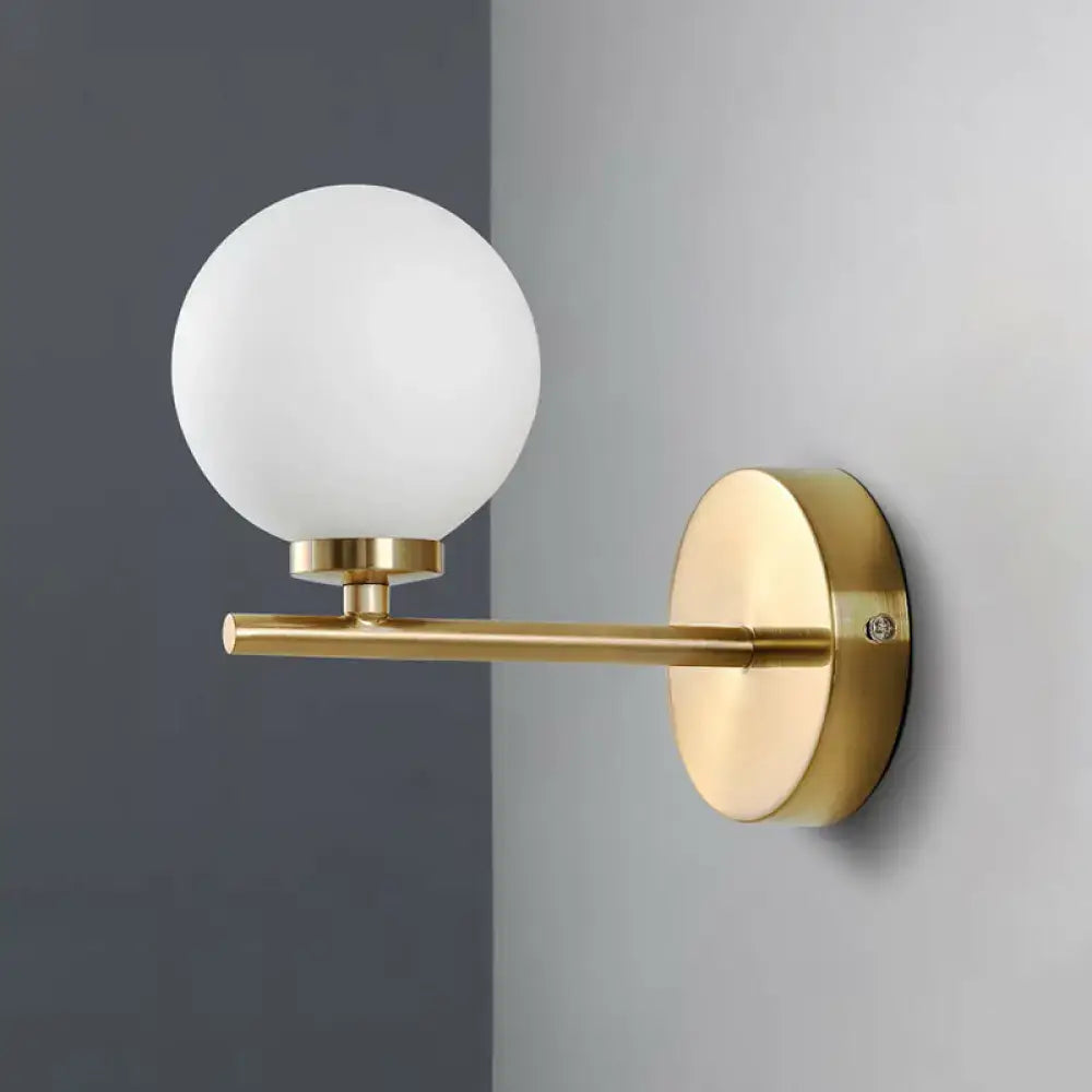 Elegant gold-toned wall sconce with frosted white ivory glass shade for bedroom wall light or wall lamp
