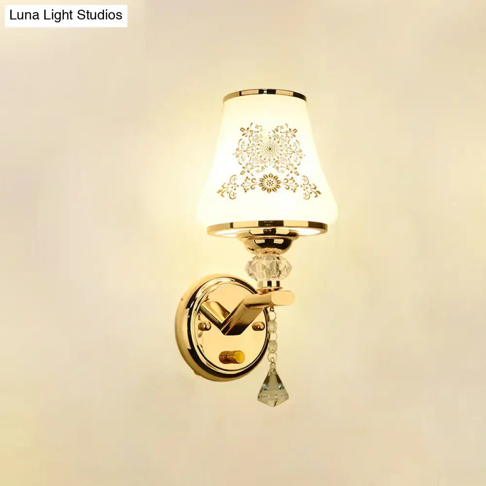 Elegant gold and white crystal wall light with ornately patterned glass shade and dangling crystal accents for reading wall light