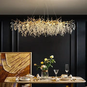 Elegant gold crystal branch chandelier with leaf design and crystal accents hanging above dining table decorbites crystal branch