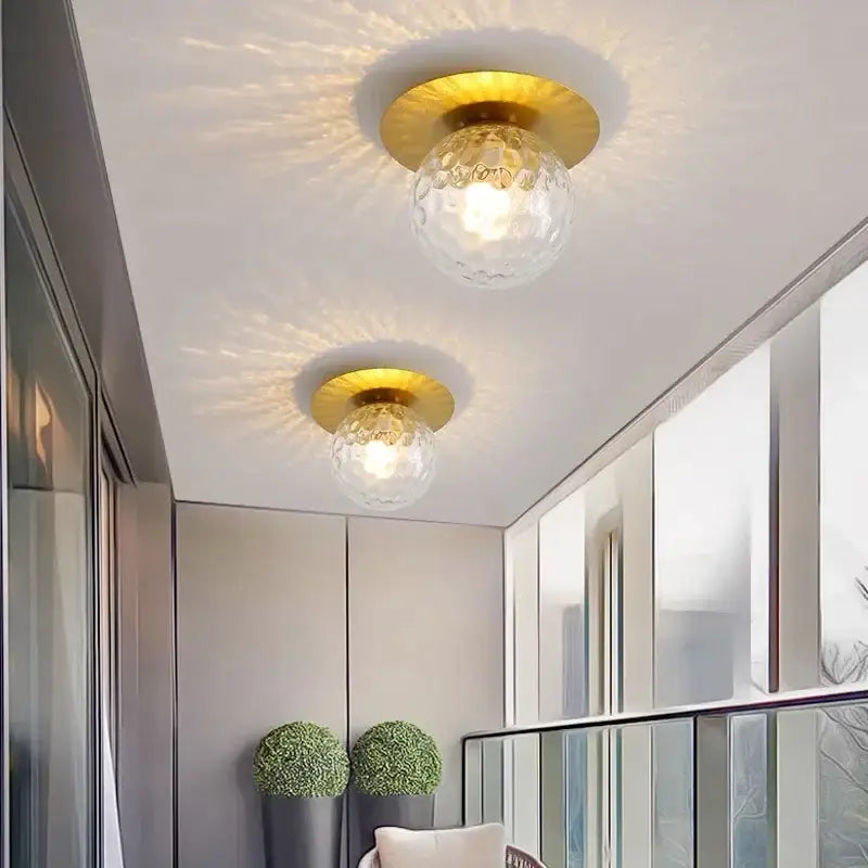 Elegant gold ceiling light fixture with textured clear glass globe shades for hallway entrance and ceiling lighting