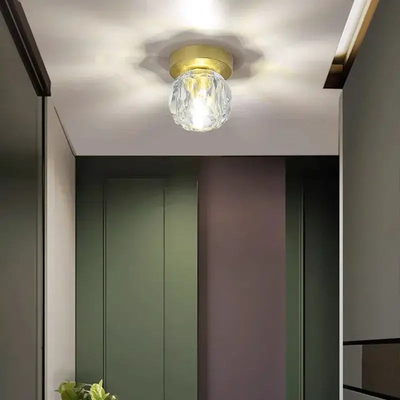 Elegant gold crystal ceiling light fixture with a gold-toned base designed for hallway entrance ceiling lighting