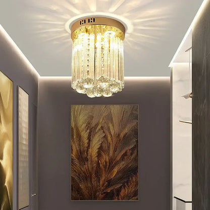 Elegant gold crystal ceiling light with cascading glass prisms and circular base for hallway decorbites elegant crystal