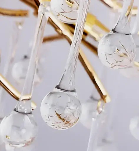 Elegant gold crystal chandelier with gold-toned branches and clear glass globe pendants with etched floral patterns
