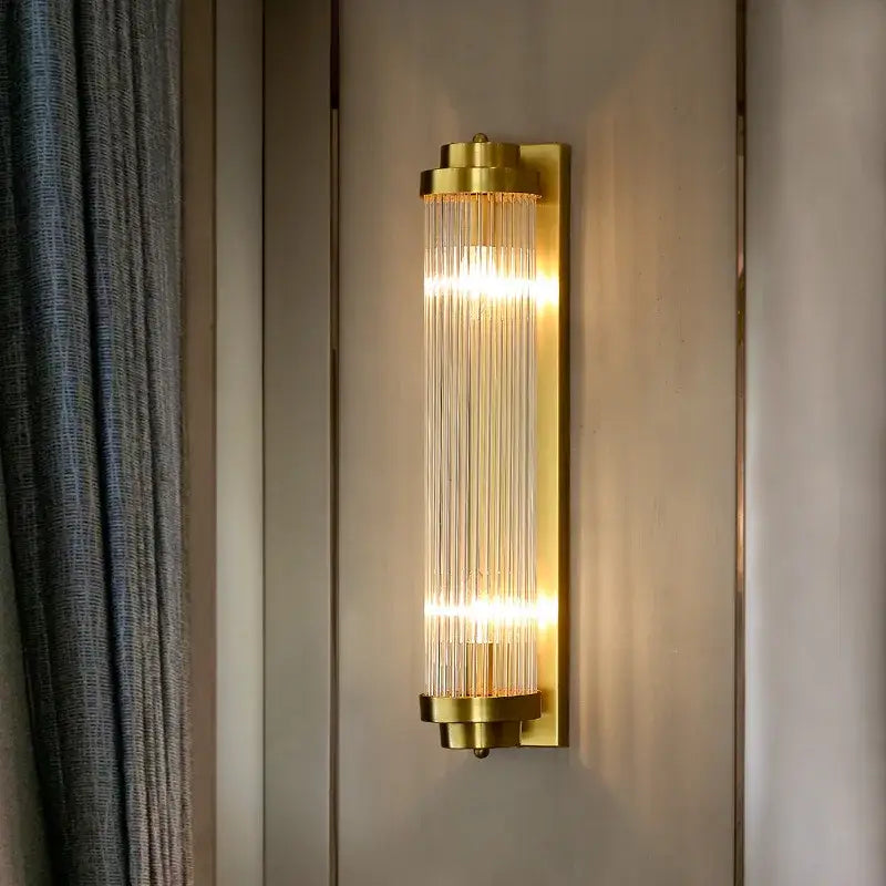 Elegant gold led wall sconce with vertical crystal rods emitting warm light for bedroom decorbites crystal led wall lamps