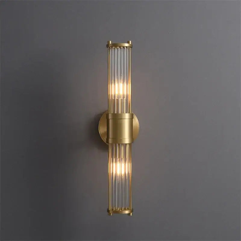 Elegant gold crystal led wall light with brass frame and vertical glass rods emitting warm glow for living room decorbites crystal led