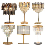 Six elegant gold crystal table decor lamps with varying designs featuring cascading glass prisms and rectangular panels