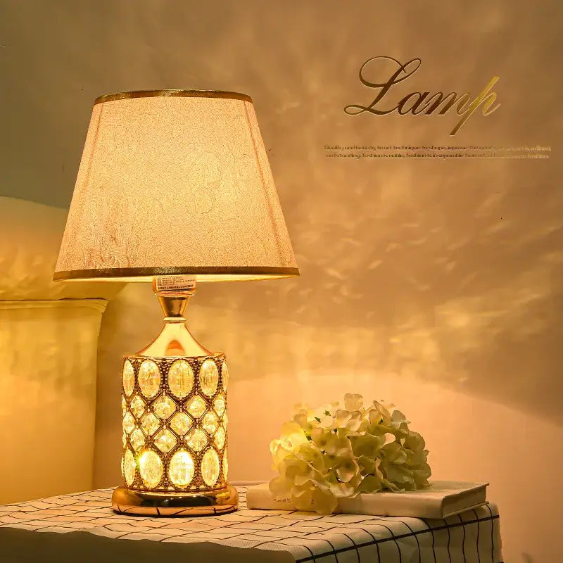 Elegant gold crystal table lamp with textured cream fabric shade and embedded oval crystals for bedroom ambiance decorbites crystal table
