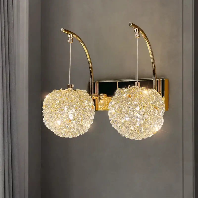 Elegant gold crystal wall lamp featuring two spherical chandeliers on curved arms for bedroom decorbites crystal wall lighting