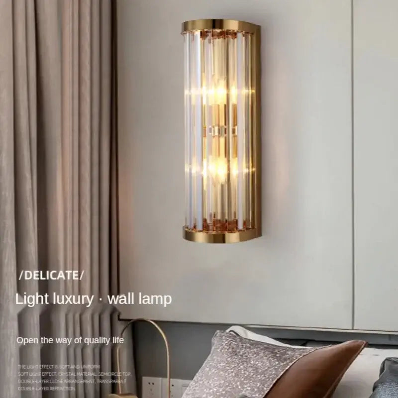 Elegant gold crystal wall lamp with a cylindrical metal frame and vertical glass rods for modern living room decorbites wall lamp