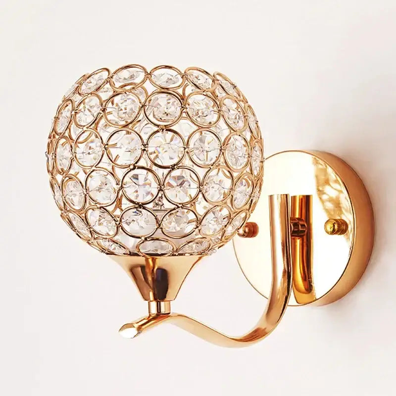Elegant gold-toned crystal wall sconce featuring a spherical globe design ideal for bedroom decorbites crystal wall lighting