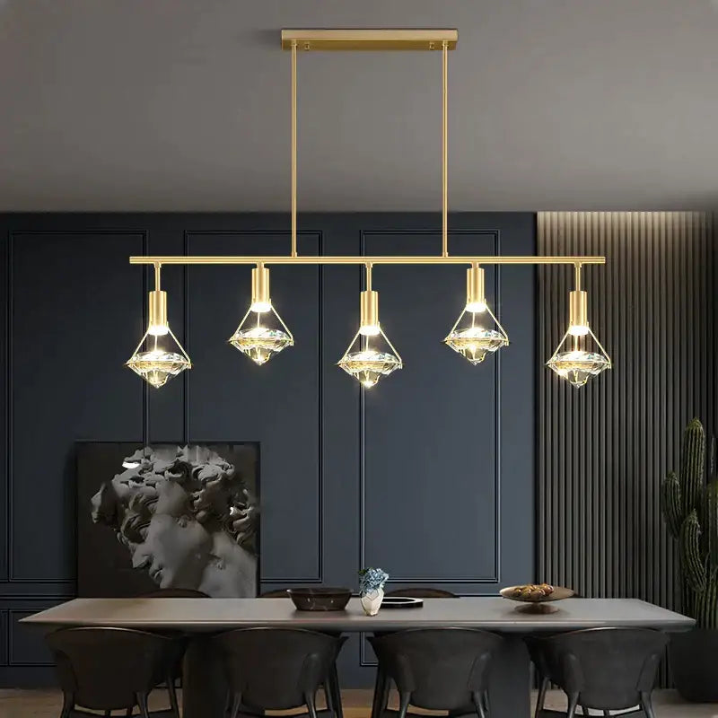 Elegant gold diamond crystal pendant light featuring five crystal-encased bulbs on a sleek horizontal bar for dining room
