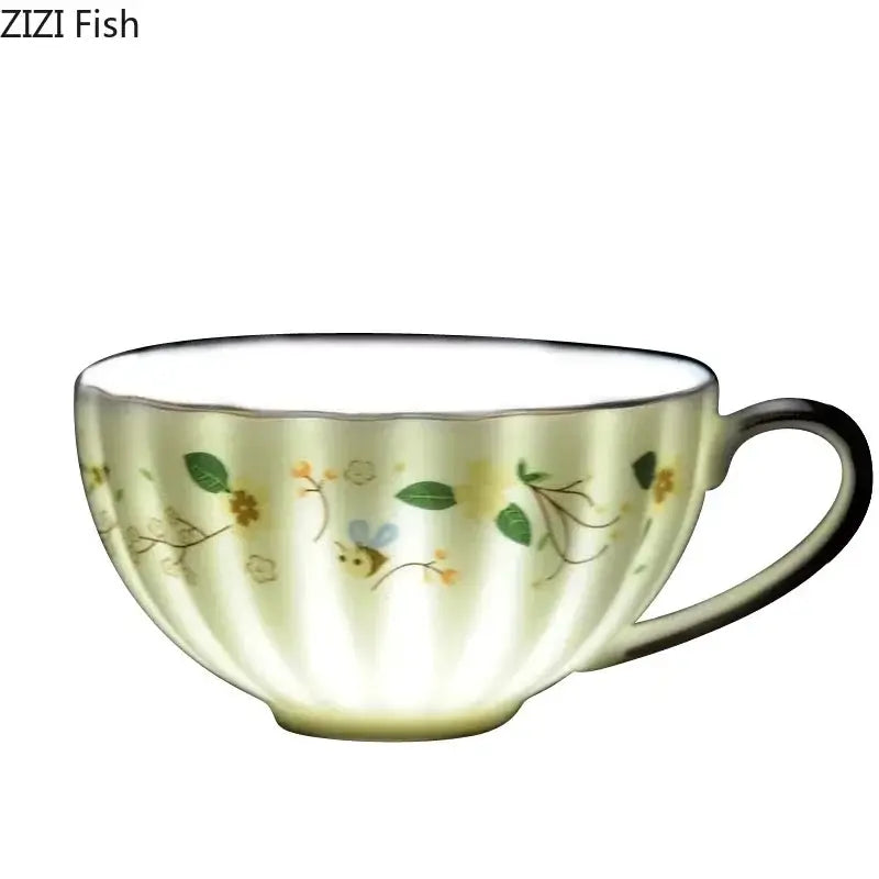 A cream-colored ceramic teacup with fluted exterior and elegant gold flower decorbites elegant gold saucer set design