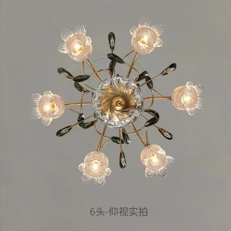 Elegant gold glass flower chandelier with six translucent flower shades dark leaf accents and brass-toned crystal hub
