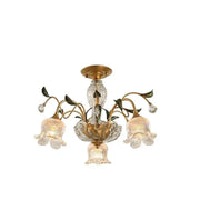Elegant gold glass flower chandelier with three bell-shaped glass shades and crystal accents for lobby lighting