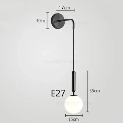 Black modern wall lamp with sleek curved arm and frosted glass globe bulb for decorbites elegant glass wall decor