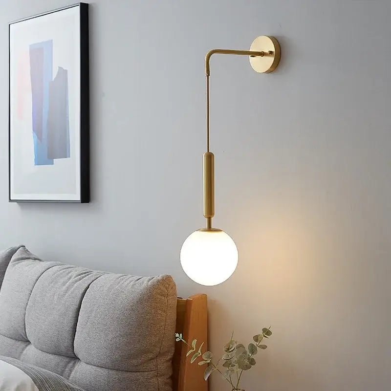 Elegant gold glass wall lamp featuring a gold-toned curved arm and frosted globe shade for stylish living room decorbites