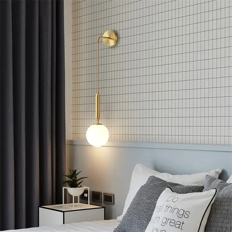 Elegant gold glass wall lamp with slender curved arm and frosted globe shade for living room decorbites elegant glass