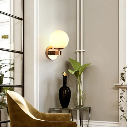 Elegant gold iron wall lamp with frosted spherical glass shade and polished brass base for bedroom decorbites iron wall lamp
