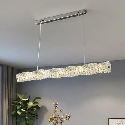 Elegant gold led crystal chandelier with elongated wavy textured design and warm lighting for dining room use