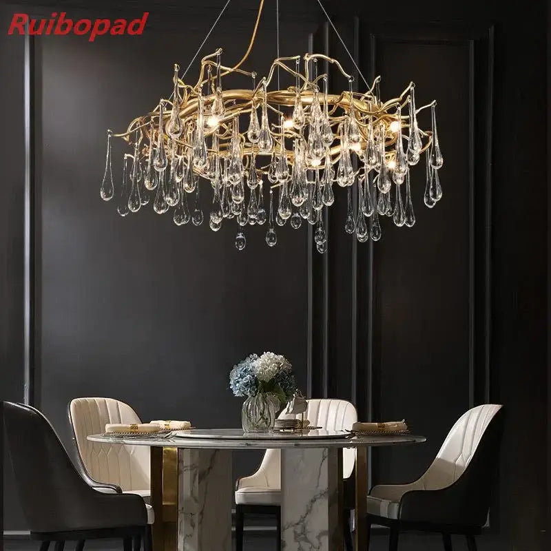 Elegant gold metal branch chandelier featuring intricate arms and glass water drop crystals for dining room lighting