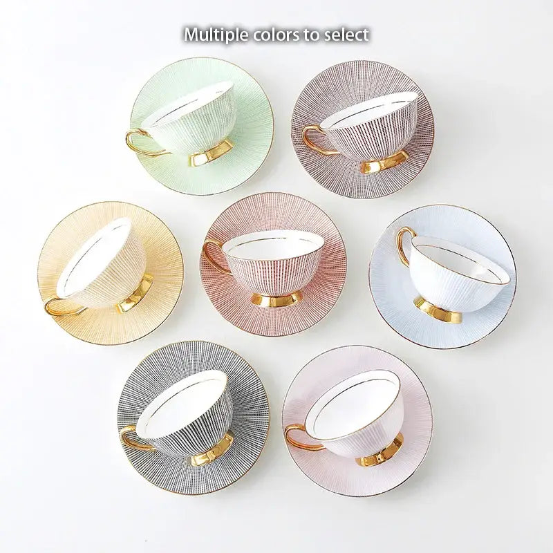Elegant gold porcelain tea set with ribbed pastel teacups and saucers featuring gold-trimmed handles on dining rack