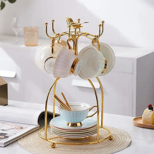 Elegant gold porcelain tea set dining room rack with bird figurine holding pastel blue white and beige ceramic teacups