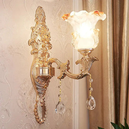 Elegant gold scrolled arm wall mount sconce with frosted glass lampshade and dangling crystal beads for bedroom lighting