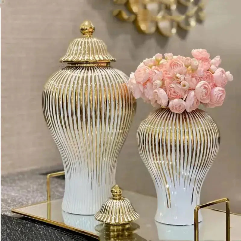 Elegant white ceramic ginger jars with gold striped decorbites design and matching lids, one holding pink roses