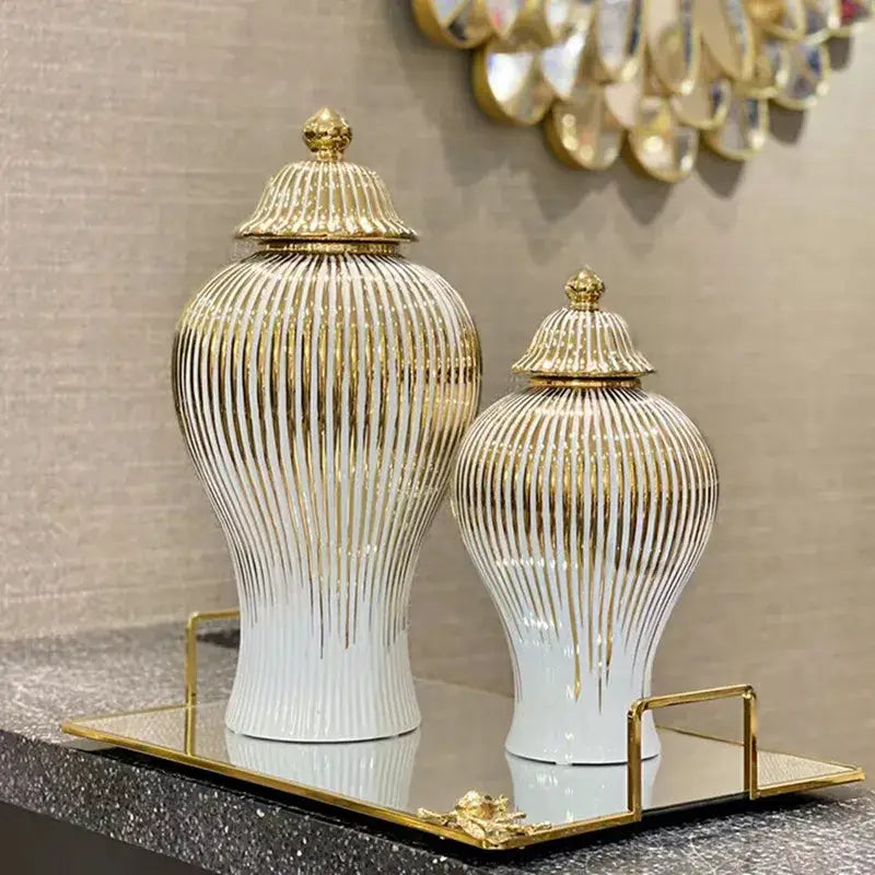 Elegant white ceramic ginger jars with gold striped accents and matching lids displayed on a mirrored tray decorbites gold striped